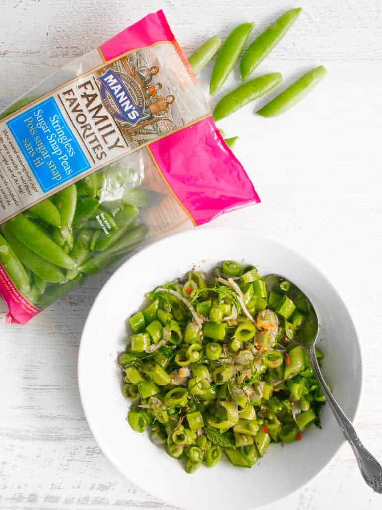 bag of sugar snap peas with chopped snap peas in salad bowl 