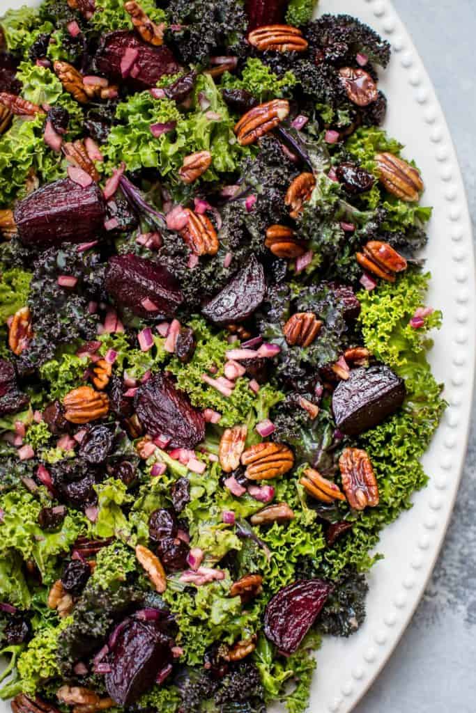 roasted beet salad with kale and pecans on white platter