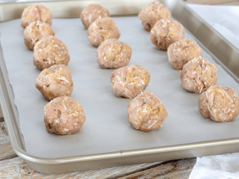 ground turkey meatballs on cookie sheet ready to bake in oven