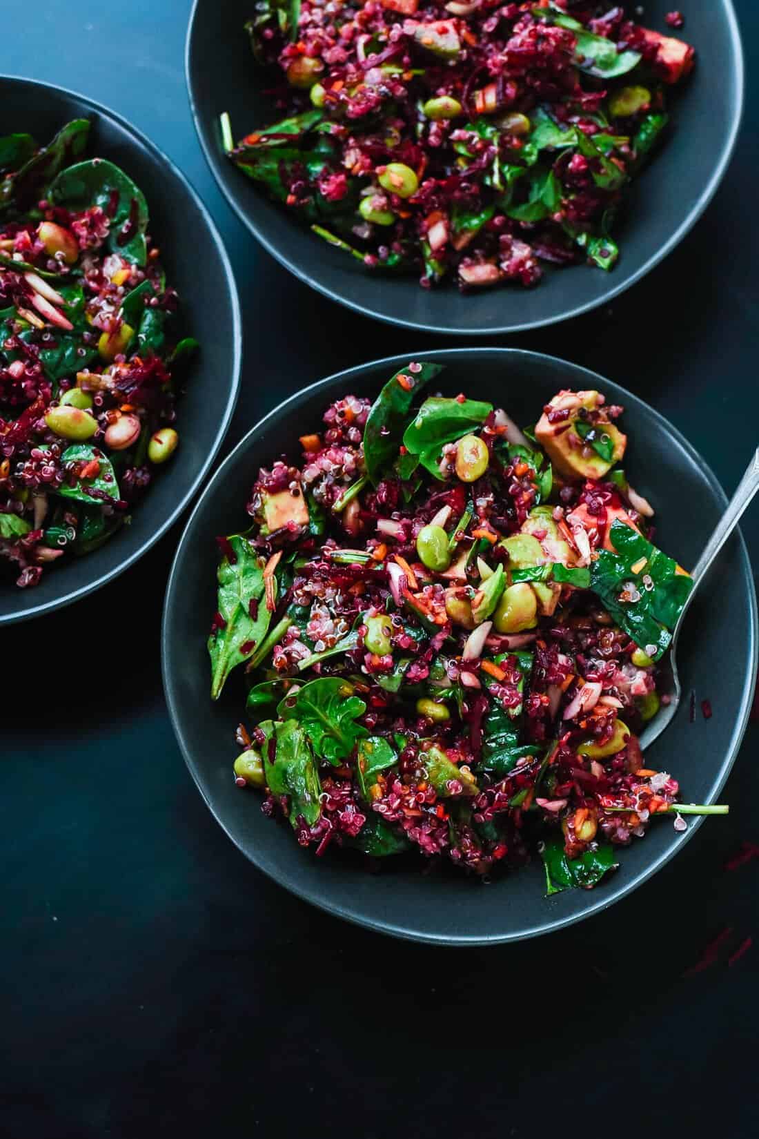 beets with quinoa, carrots and greens in a bowl