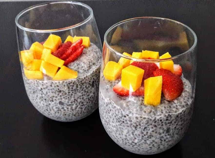coconut chia pudding in a glass dish with fresh fruit on top
