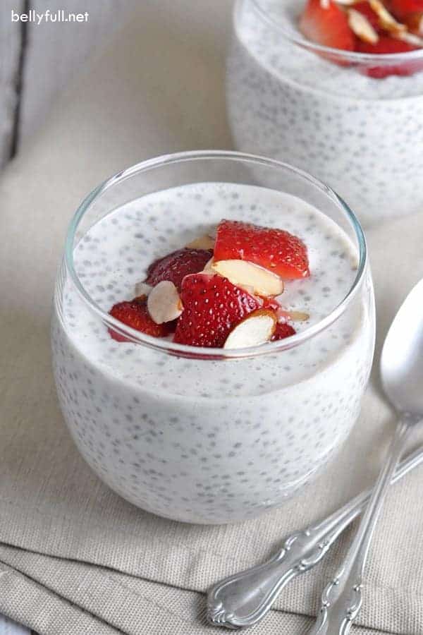 chia seed pudding in a glass dish with sliced strawberries on top