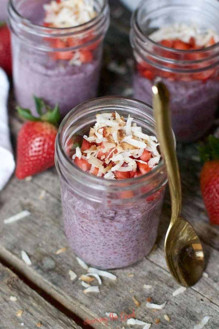 overnight oats in 3 jars with a gold plated spoon resting up against one jar
