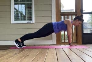 woman doing high plank shoulder taps
