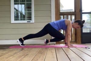 woman doing high plank to knee taps