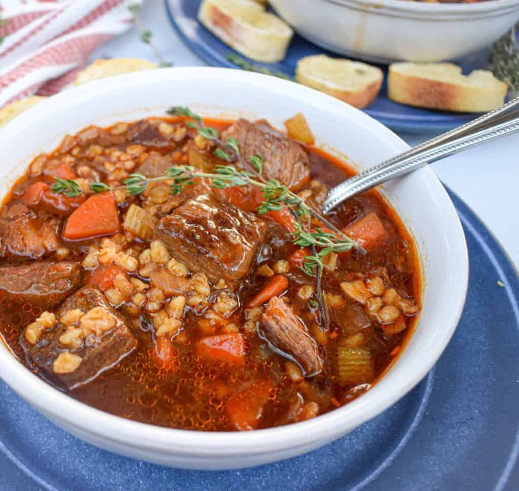 beef and barley stew in a bowl with spoon