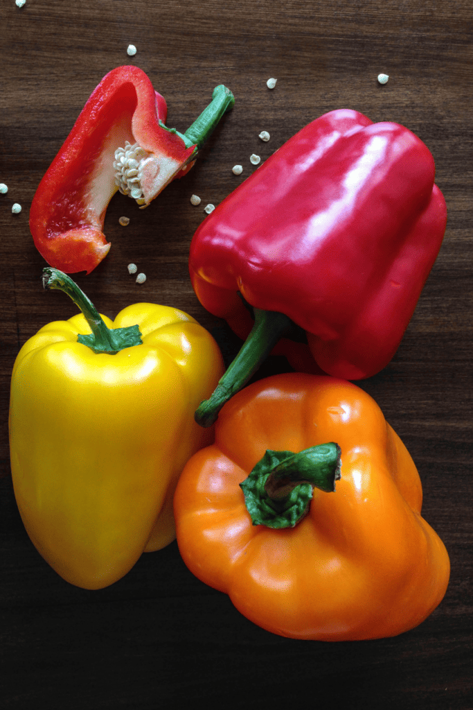 Tri Colored Bell peppers on a wooden background 